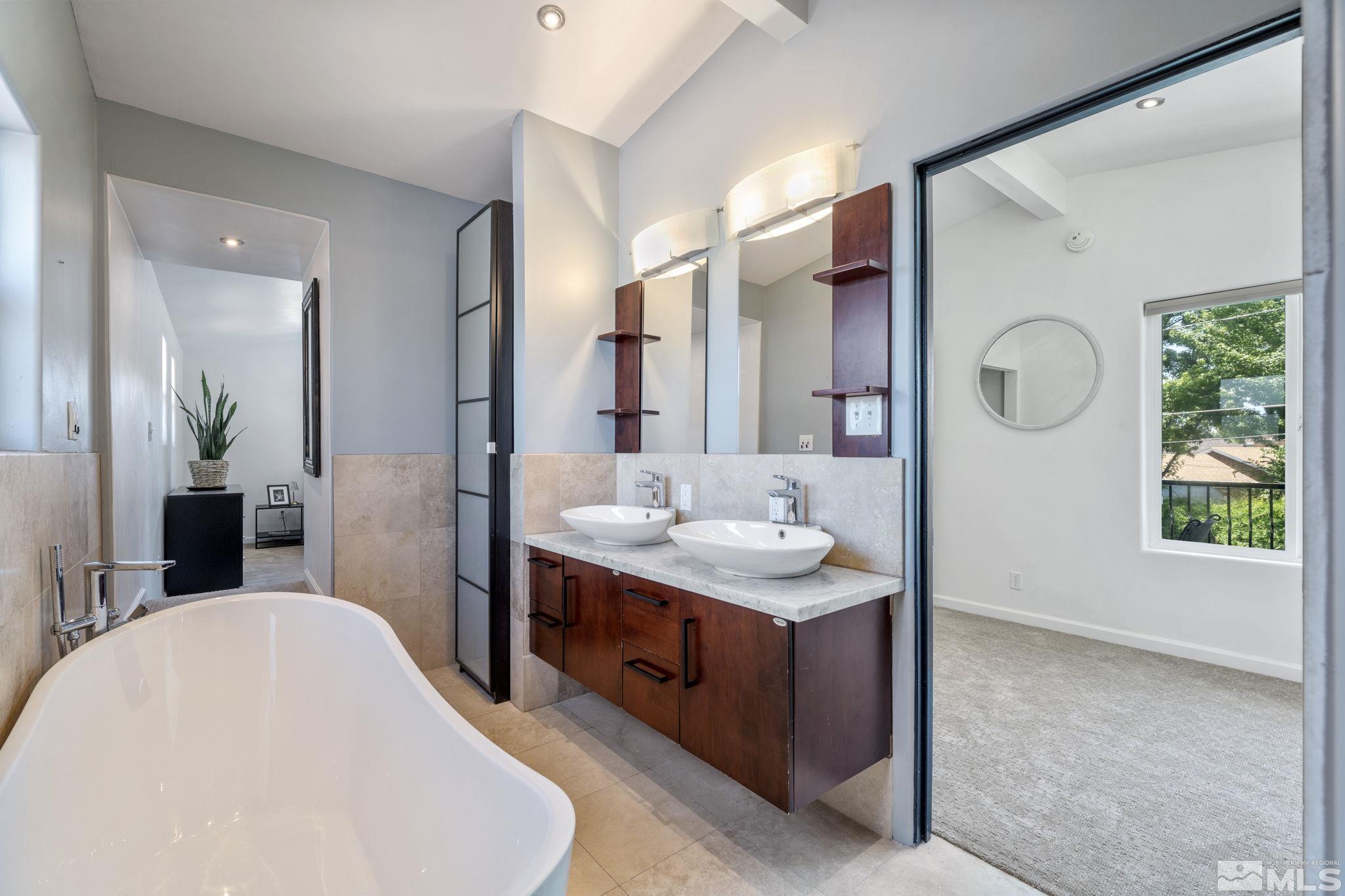 1005 Memory Lane Reno, NV 89509 - Photo 15 of 32 a en suite bathroom with a double vanity sink and a mirror