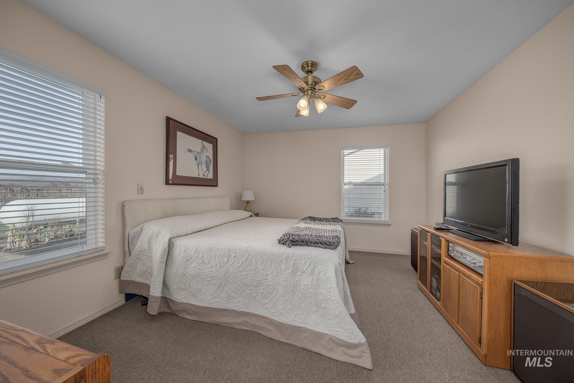 946 Indianhead Road Weiser, ID 83672 - Photo 12 of 36 Bedroom featuring light colored carpet and ceiling fan