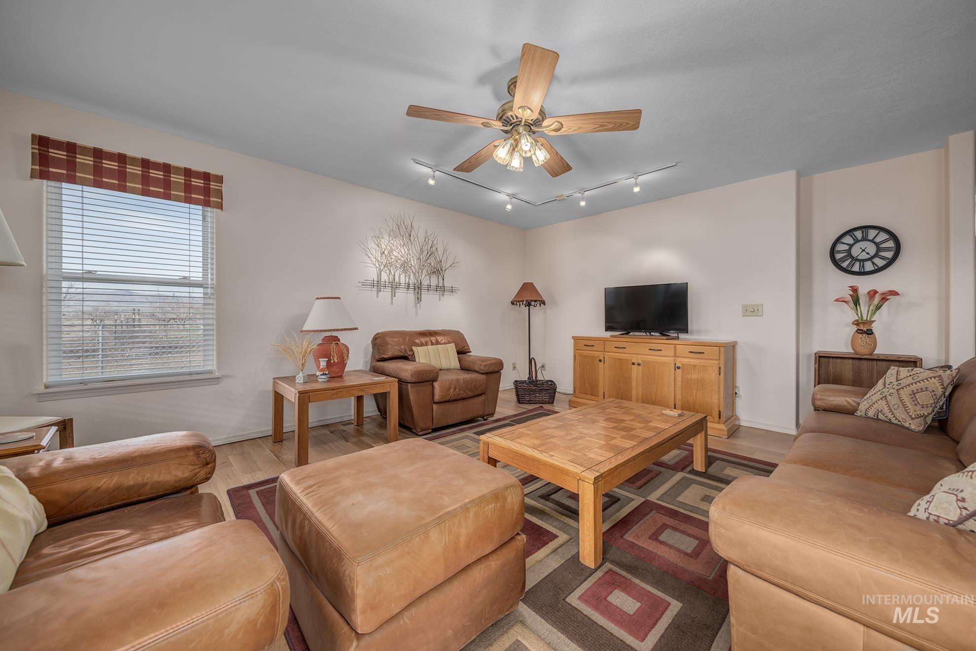 946 Indianhead Road Weiser, ID 83672 - Photo 4 of 36 Living room featuring rail lighting, ceiling fan, and wood finished floors