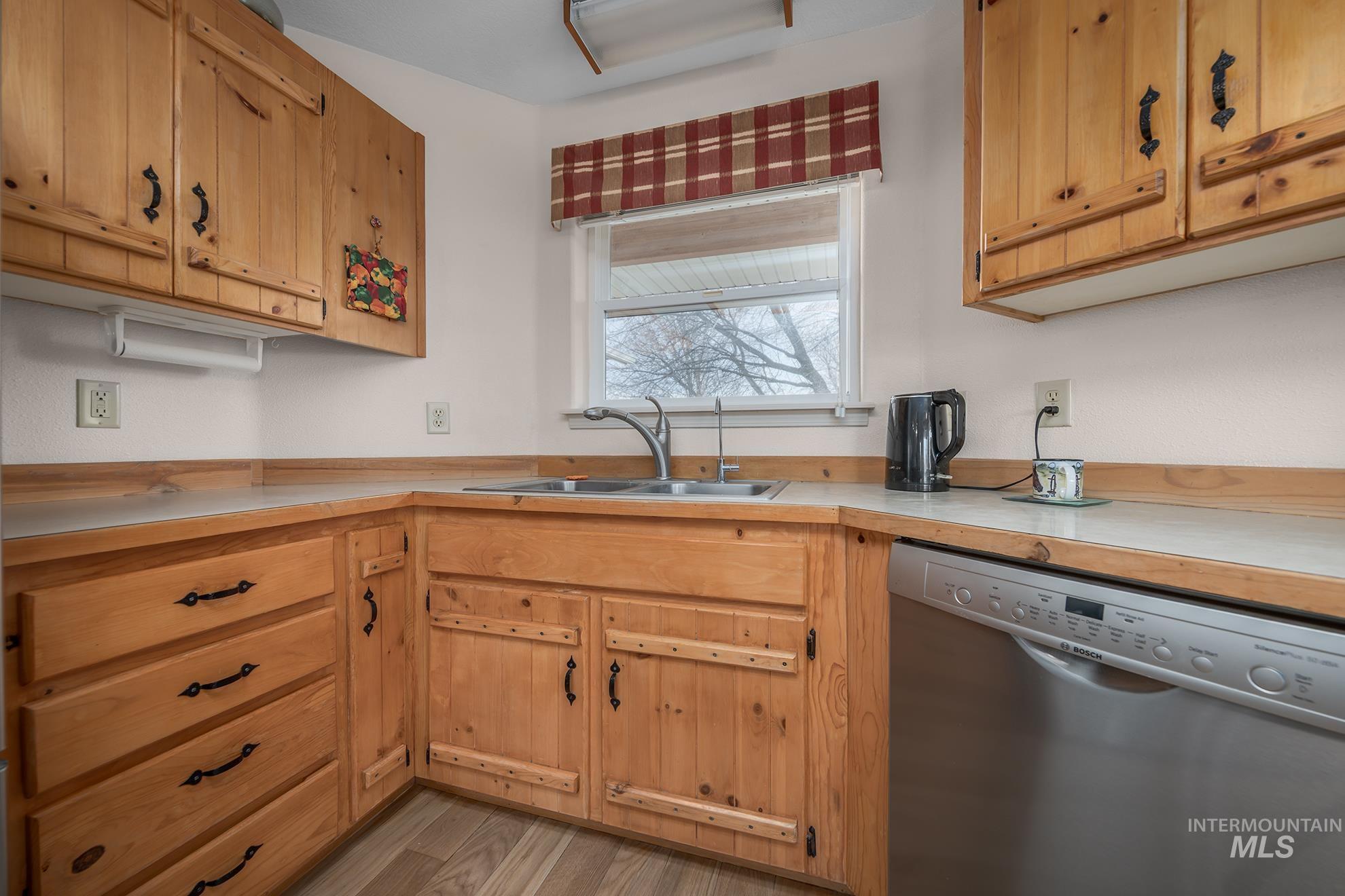 946 Indianhead Road Weiser, ID 83672 - Photo 9 of 36 Kitchen with stainless steel dishwasher, light countertops, and light wood-style floors