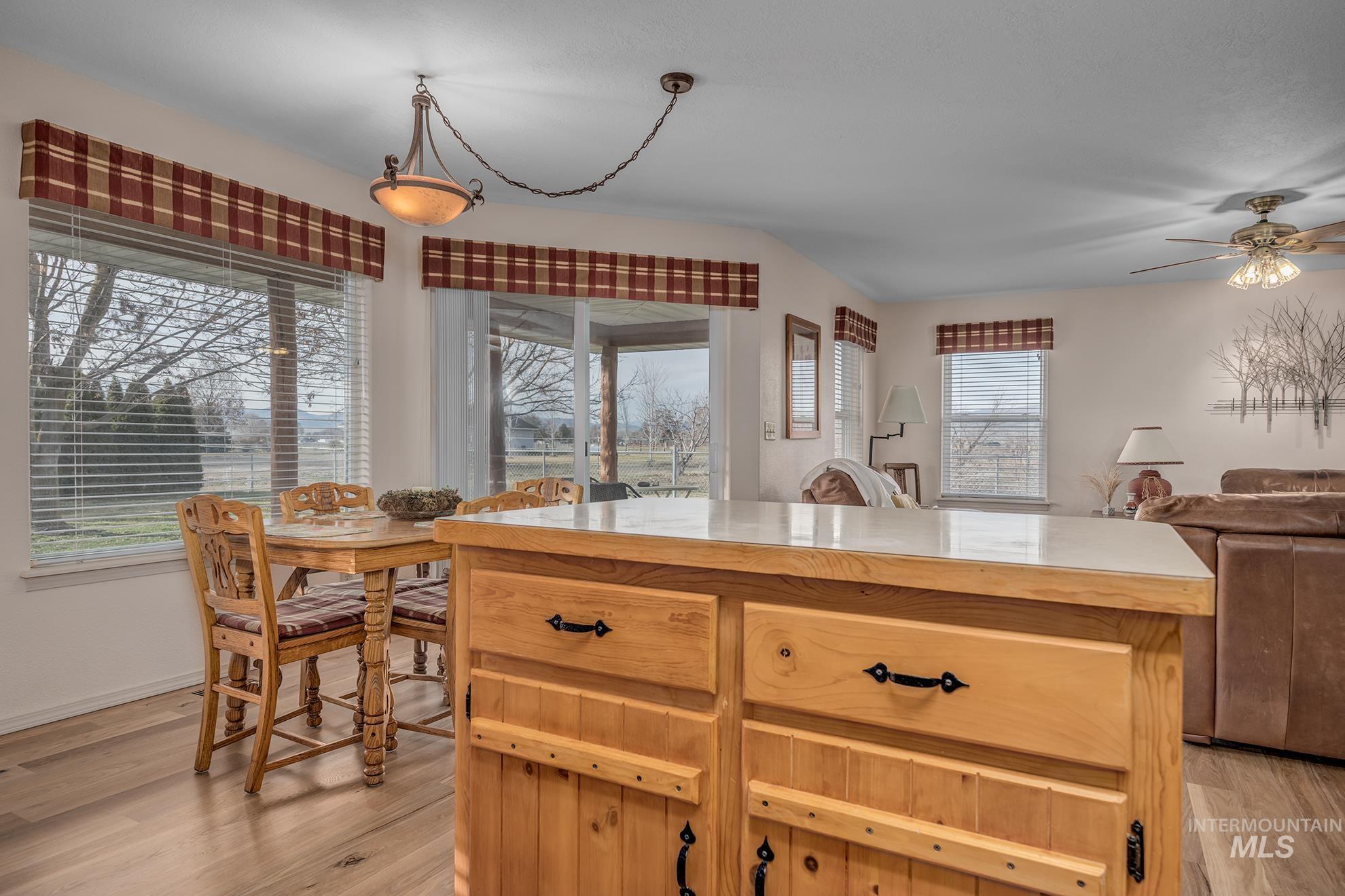 946 Indianhead Road Weiser, ID 83672 - Photo 36 of 36 Kitchen featuring a ceiling fan, light wood-type flooring, decorative light fixtures, light wood finish cabinetry, and open floor plan