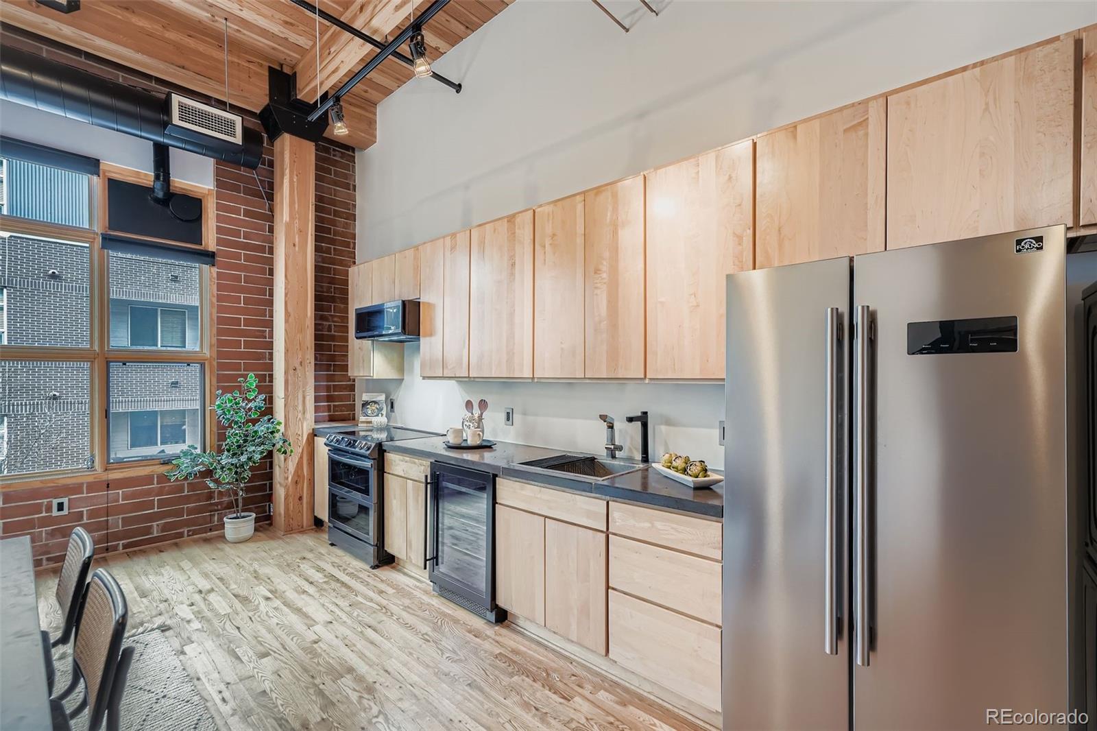 2955 Inca Street, Unit 2H Denver, CO 80202 - Photo 2 of 20 a kitchen with a refrigerator a sink and cabinets