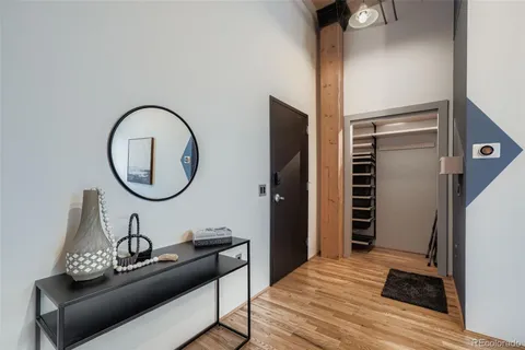 a living room with furniture a mirror and a wooden floor