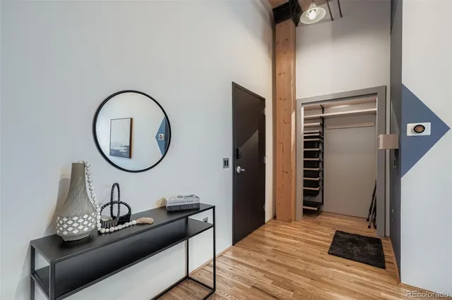 a living room with furniture a mirror and a wooden floor
