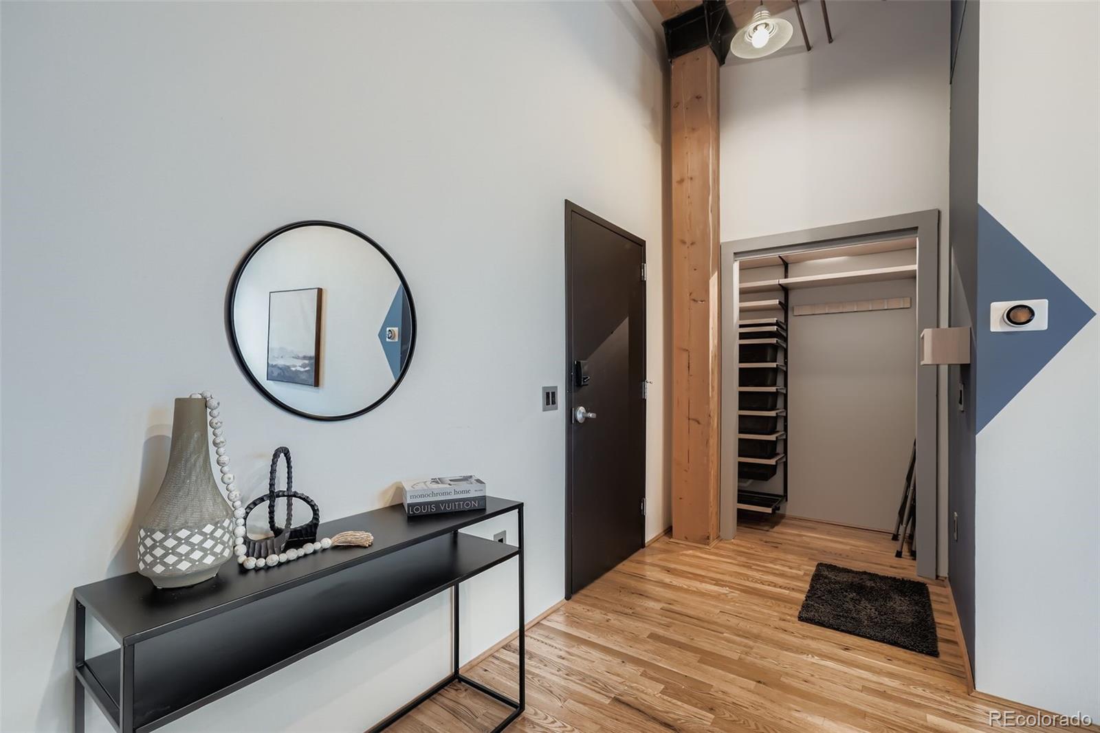 2955 Inca Street, Unit 2H Denver, CO 80202 - Photo 10 of 20 a living room with furniture a mirror and a wooden floor