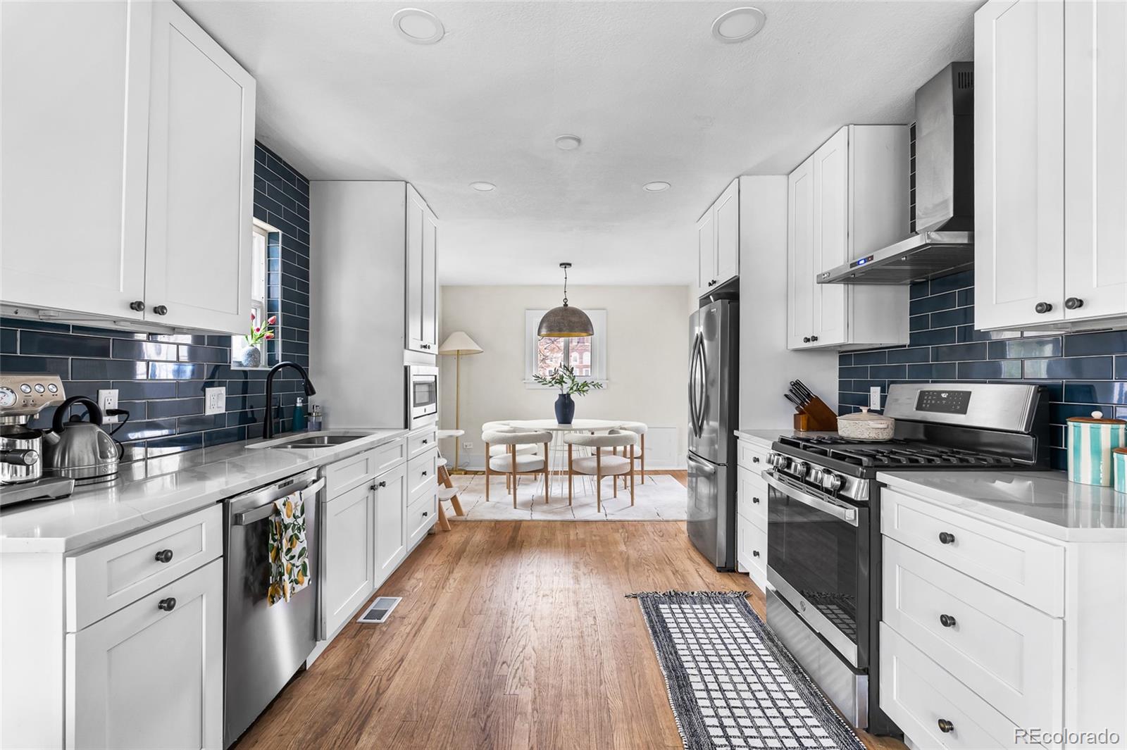 1445 Ash Street Denver, CO 80220 - Photo 15 of 45 a kitchen with stainless steel appliances a stove sink and cabinets