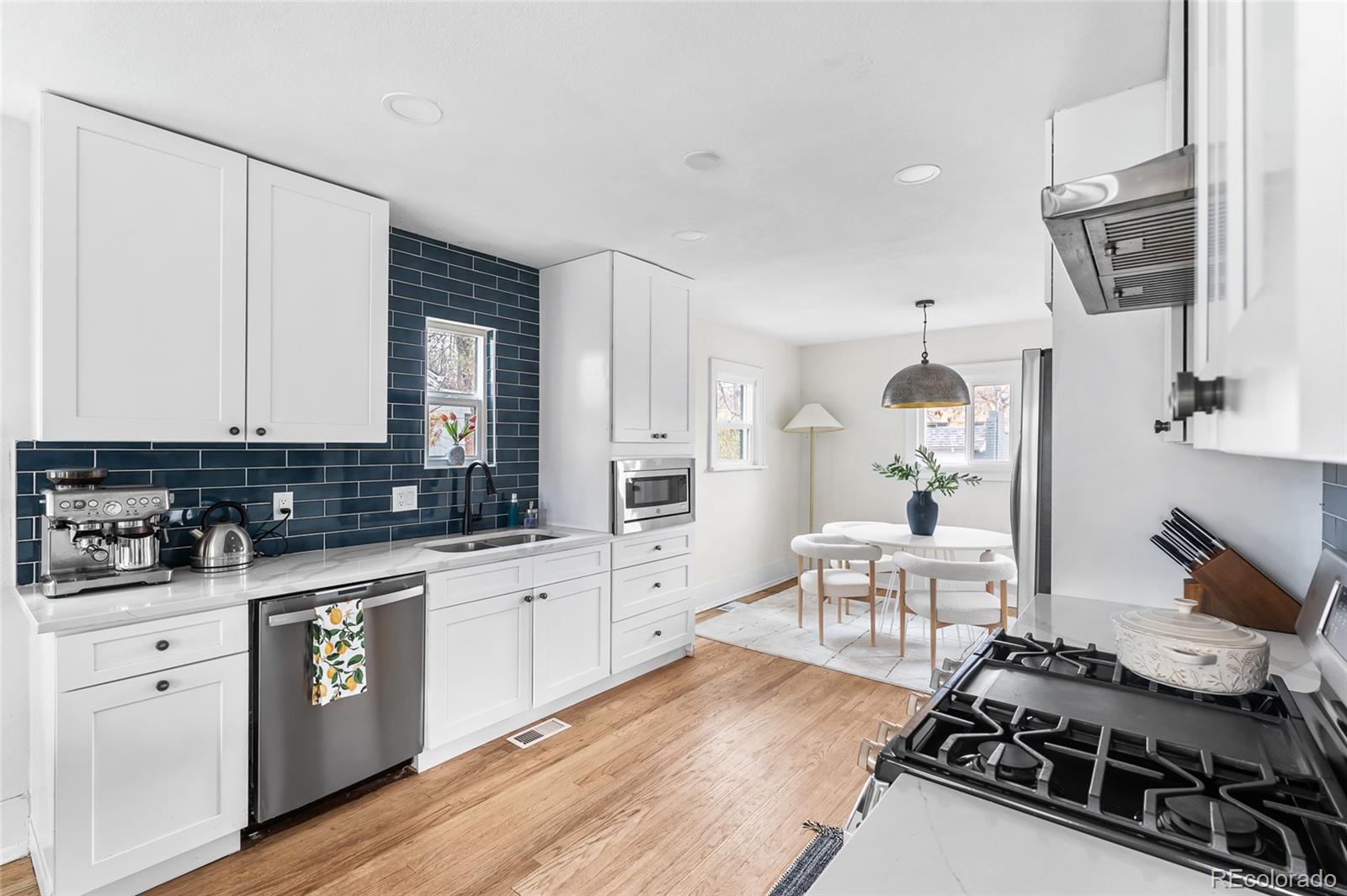 1445 Ash Street Denver, CO 80220 - Photo 16 of 45 a kitchen with stainless steel appliances a sink stove and cabinets
