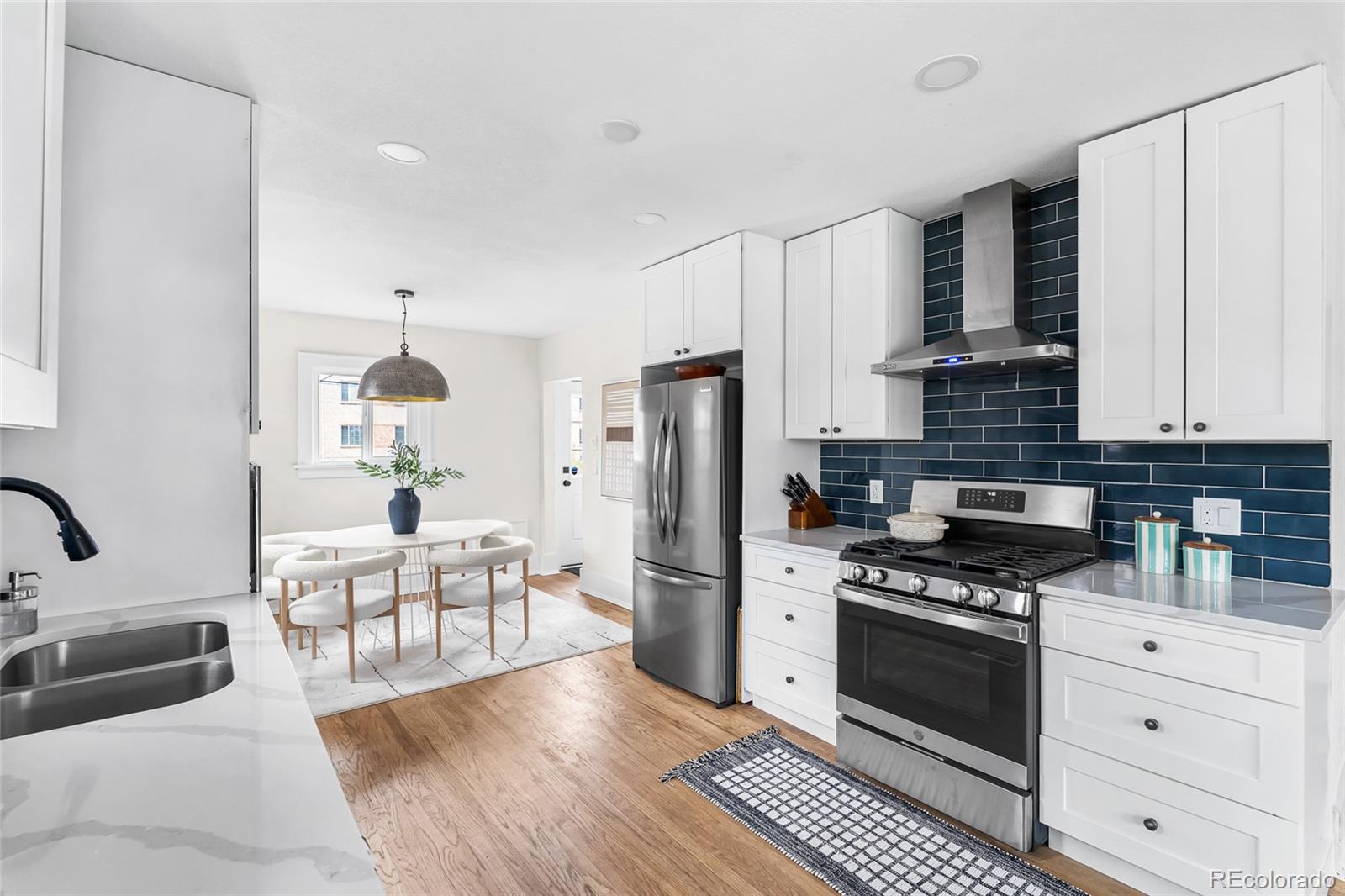 1445 Ash Street Denver, CO 80220 - Photo 17 of 45 a kitchen with white cabinets and stainless steel appliances