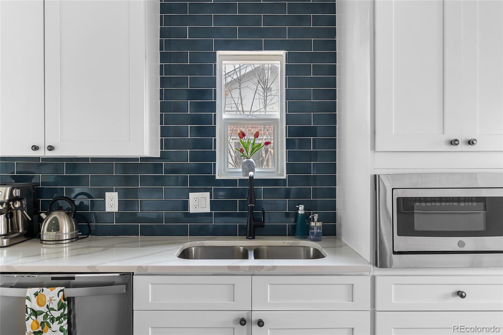 1445 Ash Street Denver, CO 80220 - Photo 23 of 45 a kitchen with a sink and cabinets