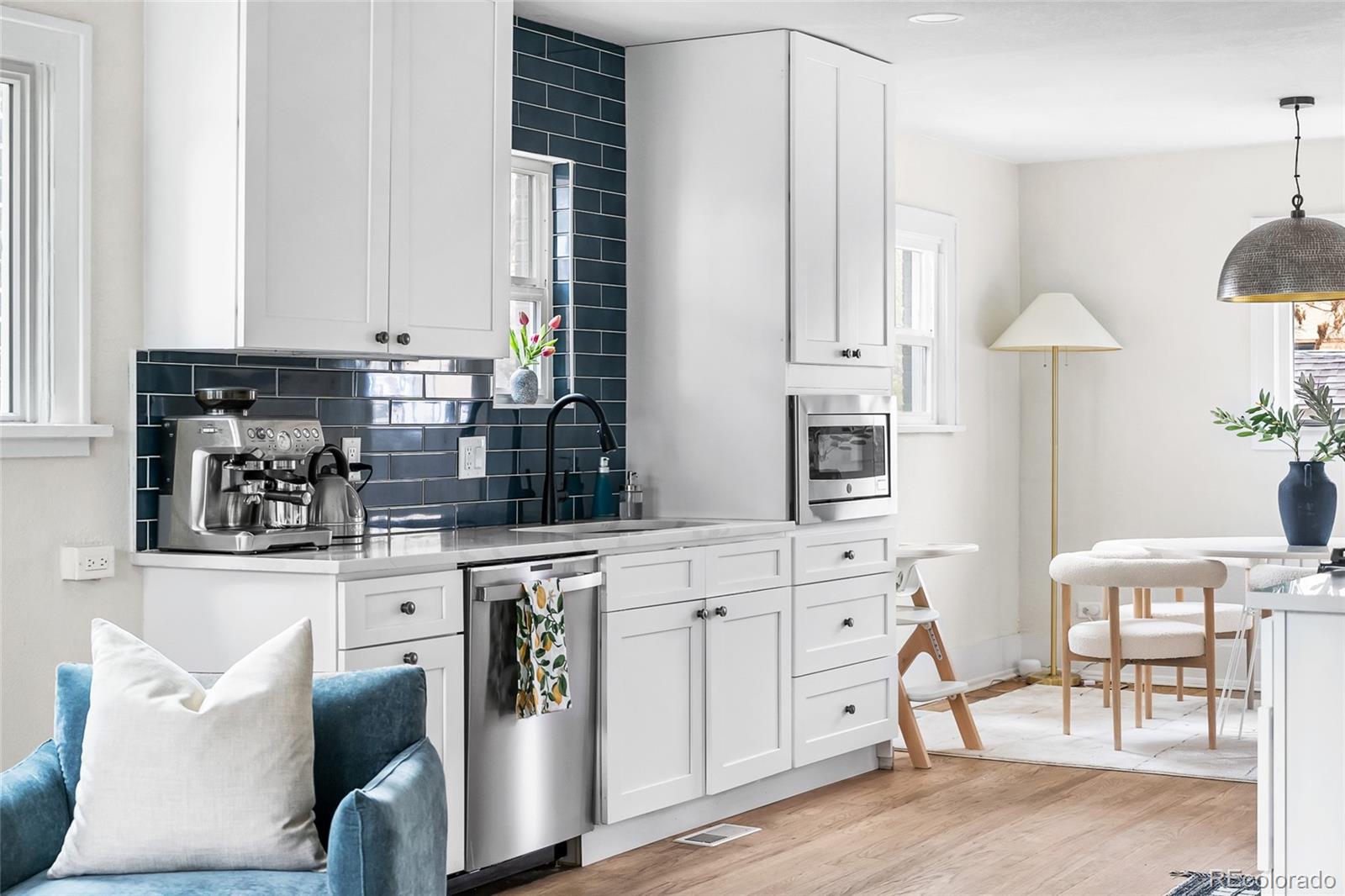 1445 Ash Street Denver, CO 80220 - Photo 8 of 45 a kitchen with stainless steel appliances kitchen island granite countertop a table and chairs in it