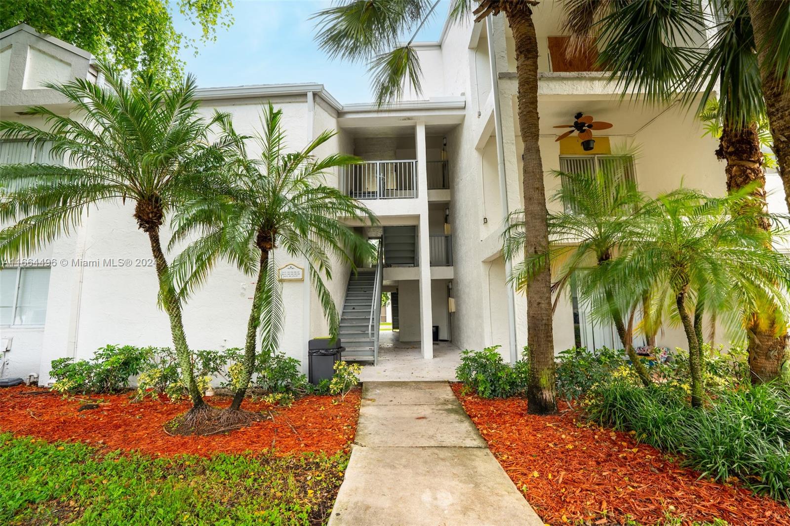 5672 Rock Island Road, Unit 259 Tamarac, FL 33319 - Photo 1 of 31 front view of a house with a yard and palm trees
