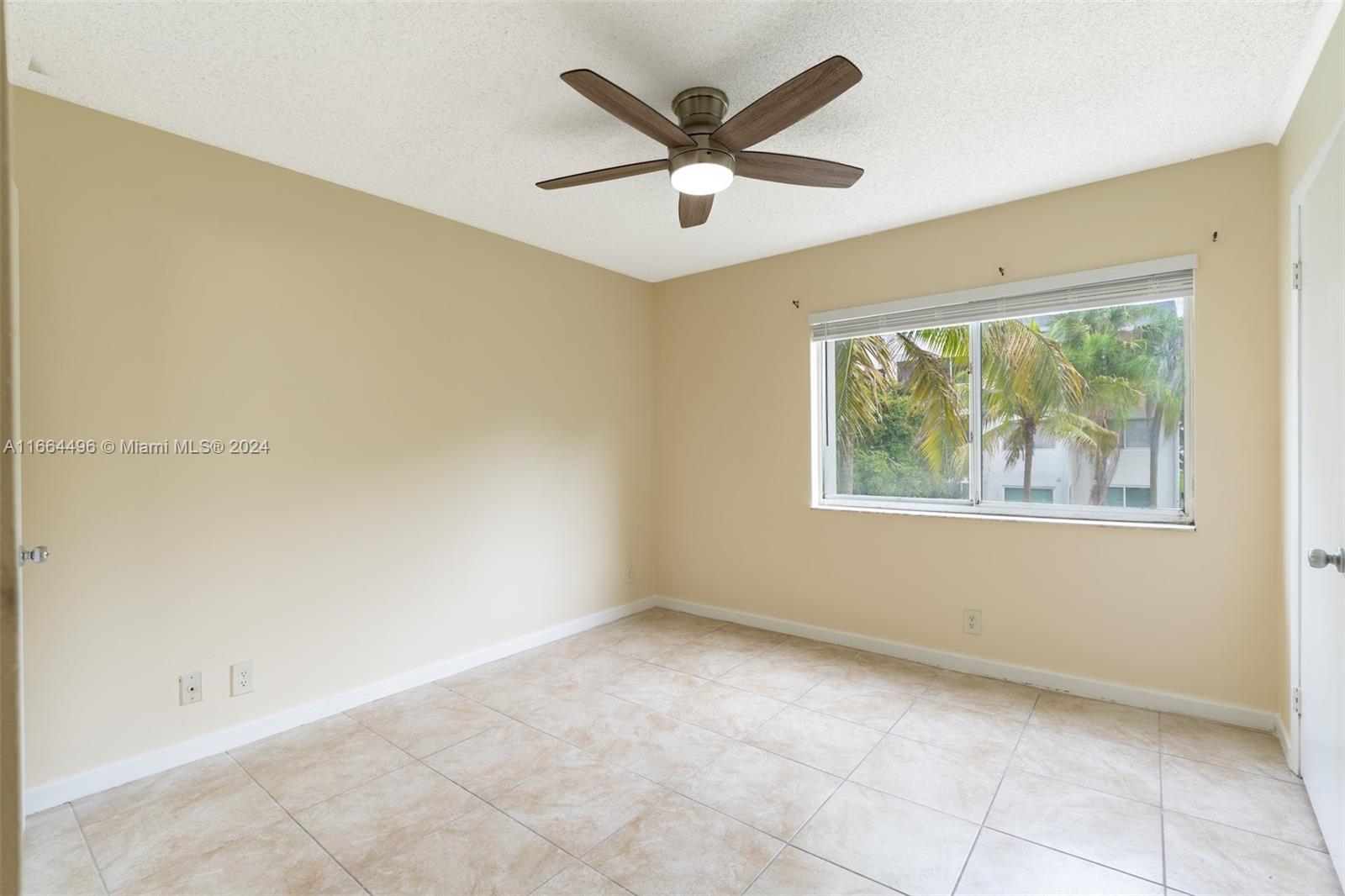 5672 Rock Island Road, Unit 259 Tamarac, FL 33319 - Photo 14 of 31 an empty room with windows and ceiling fan