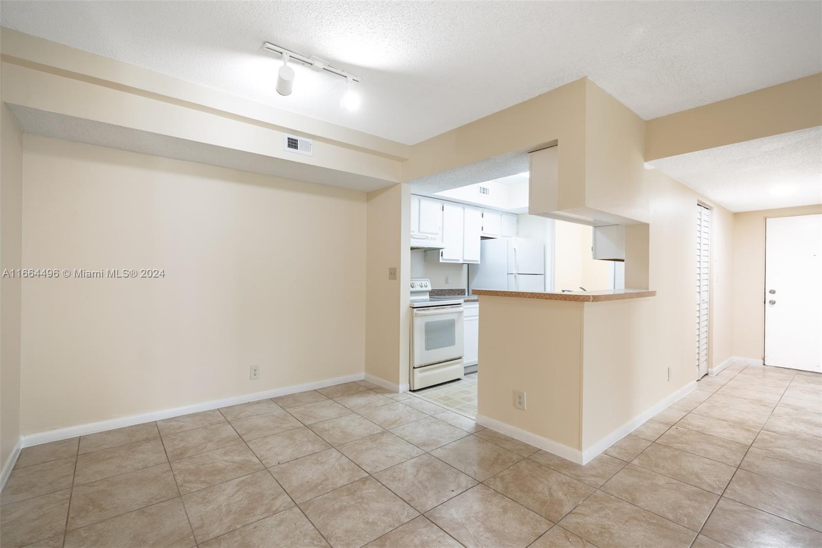 5672 Rock Island Road, Unit 259 Tamarac, FL 33319 - Photo 2 of 31 a kitchen with white cabinets and white appliances