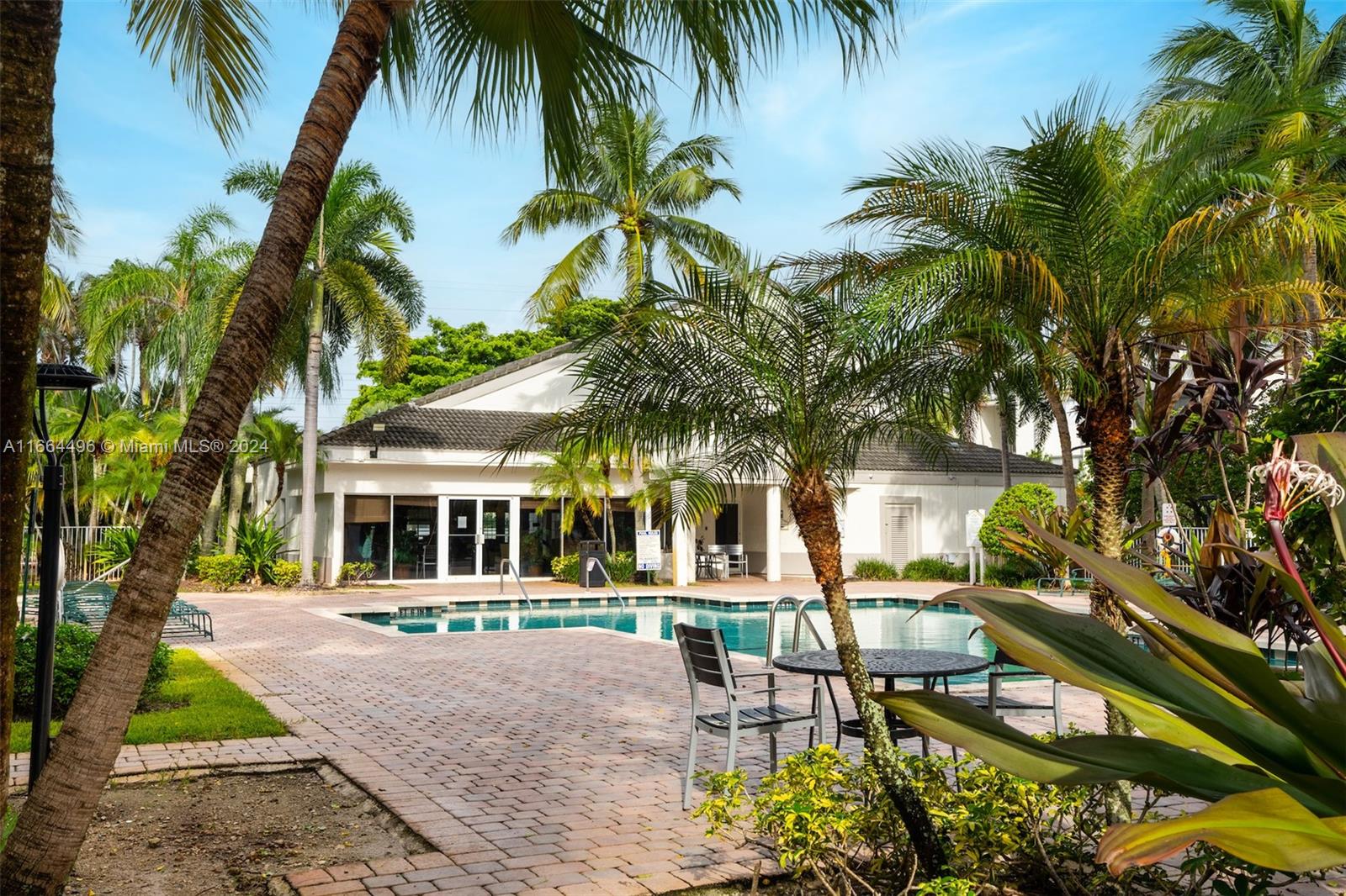 5672 Rock Island Road, Unit 259 Tamarac, FL 33319 - Photo 31 of 31 a row of palm trees and swimming pool in the backyard of a house