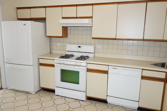 1261 Ranchview Court Buffalo Grove, IL 60089 - Photo 9 of 23 a kitchen with white cabinets and white appliances