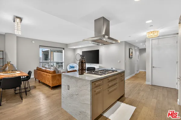 a living room with kitchen island furniture and a flat screen tv