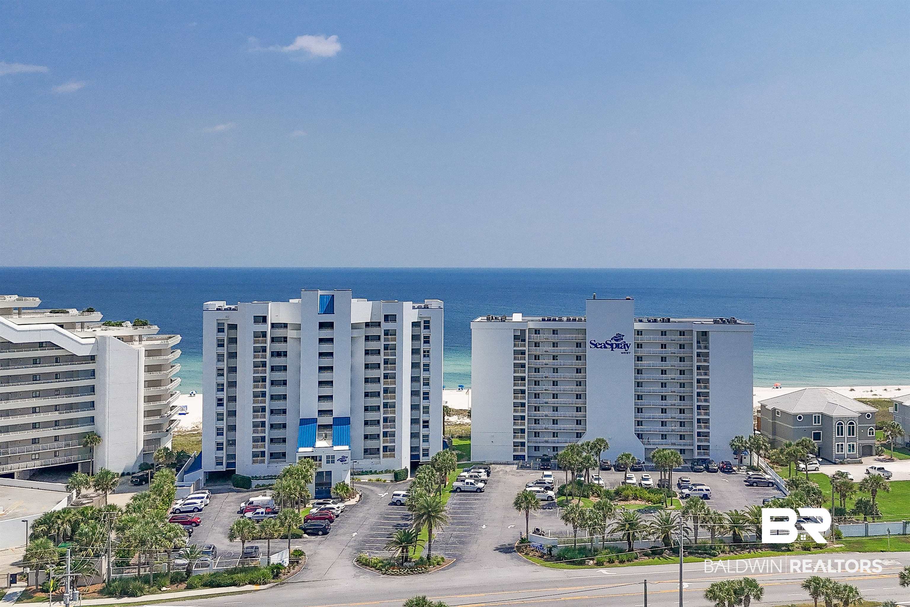 16287 Perdido Key Drive, Unit 105 Pensacola, FL 32507 - Photo 2 of 66 Coastal high-rise residences featuring private balconies, ample parking, palm tree landscaping, and direct access to a white sand beach and the Gulf of Mexico