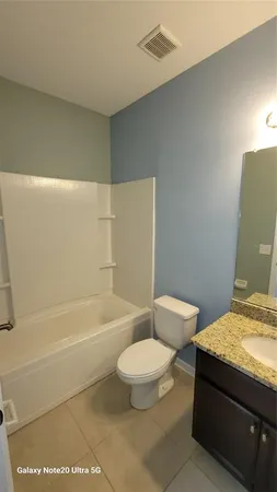 a bathroom with a granite countertop toilet a sink and bathtub