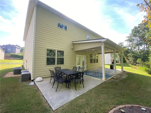 a view of a house with a backyard and a patio