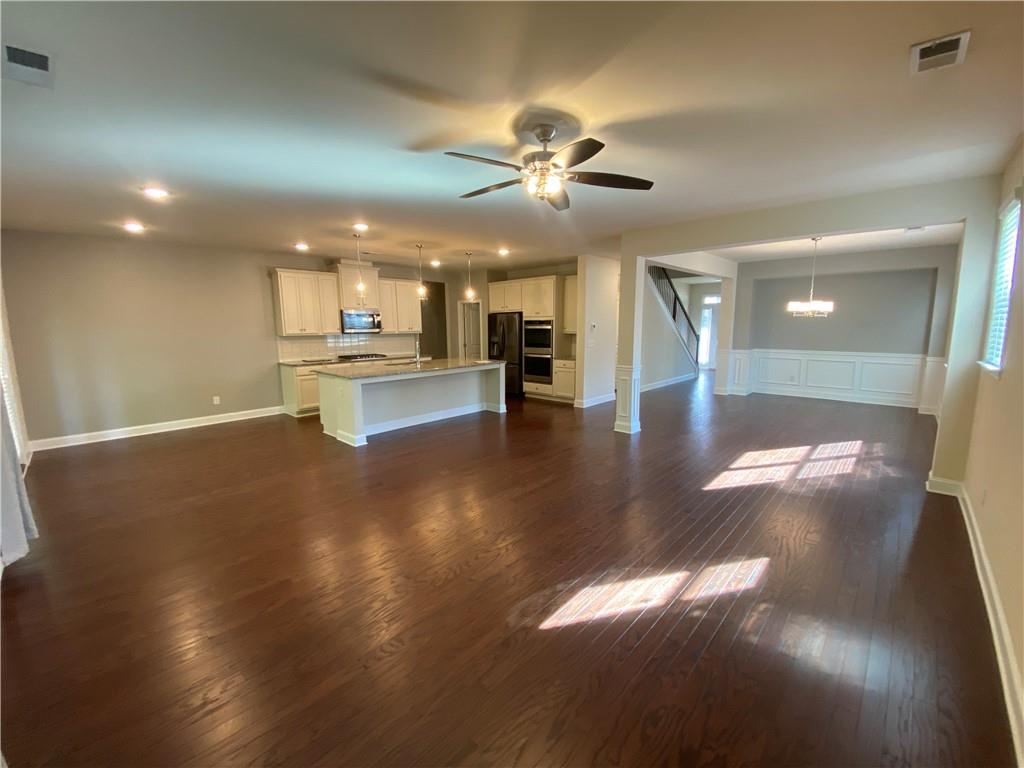 4870 Odum View Lane Cumming, GA 30040 - Photo 5 of 23 a view of a living room and kitchen with a flat screen tv