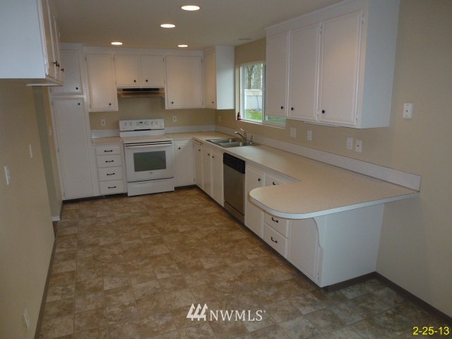 22010 7th Place West Bothell, WA 98021 - Photo 5 of 15 a kitchen with white cabinets and white appliances