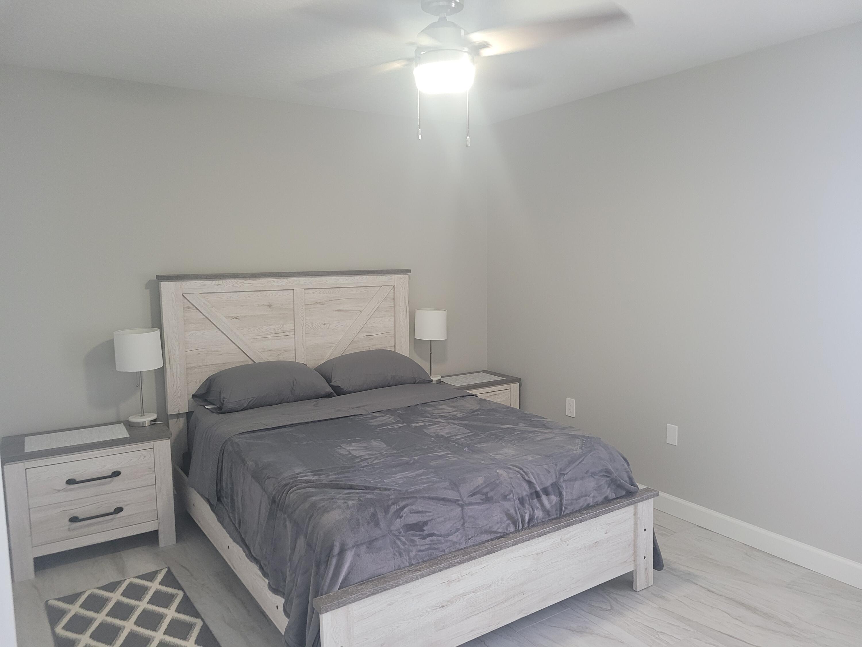 511 West Pine Street, Unit B Lantana, FL 33462 - Photo 2 of 11 a bedroom with a bed and a night stand