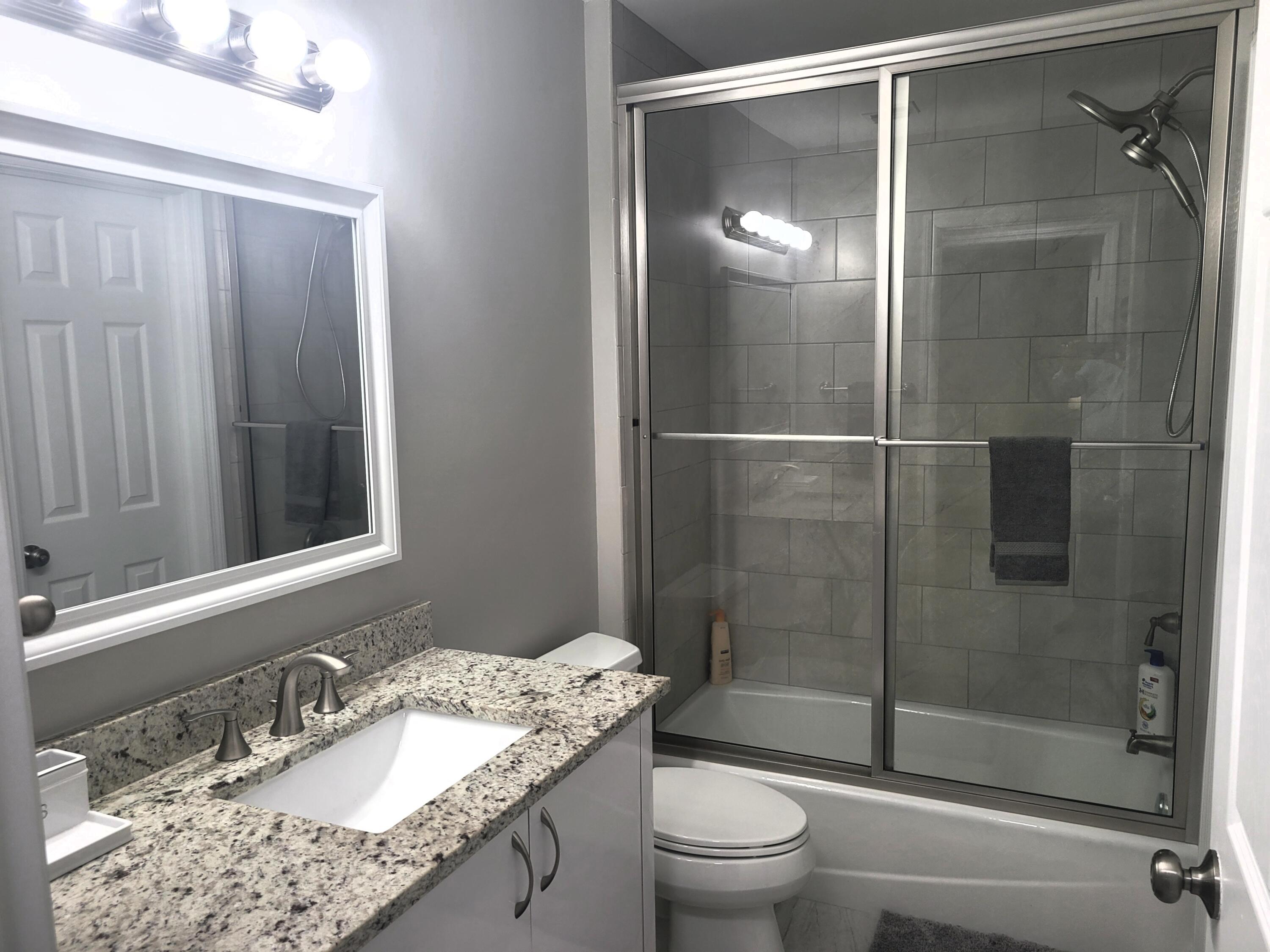 511 West Pine Street, Unit B Lantana, FL 33462 - Photo 3 of 11 a bathroom with a granite countertop sink toilet and shower