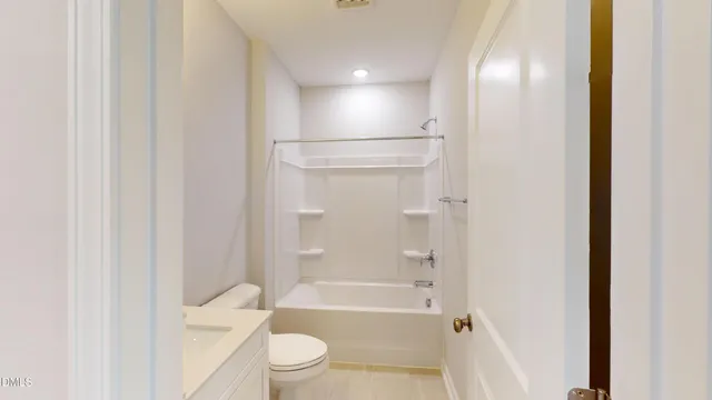 a bathroom with a bathtub shower sink vanity and toilet