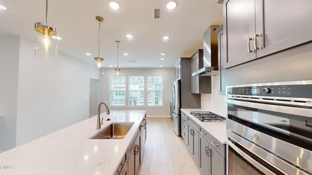 a kitchen with stainless steel appliances granite countertop a sink a stove and a refrigerator