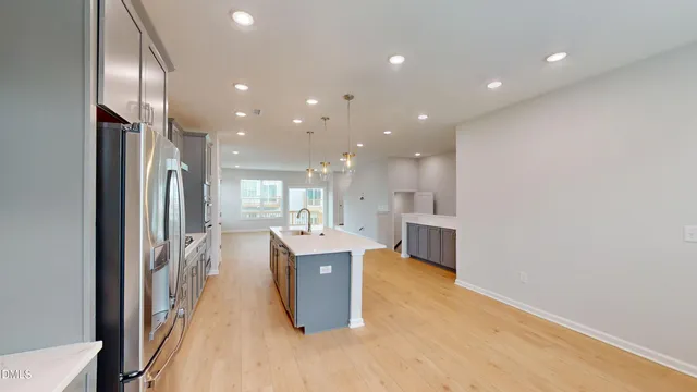 a open kitchen with kitchen island a sink stove and refrigerator