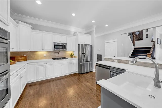 a spacious bedroom with a bed a chandelier and next to a window