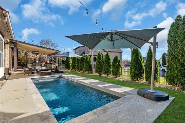 a view of a patio with a table and chairs under an umbrella