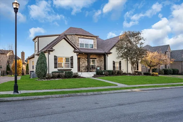 a front view of a house with a yard and trees