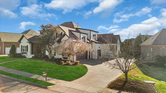 an aerial view of a house with swimming pool and large trees