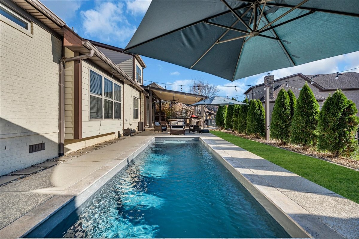 1021 Alice Springs Circle Spring Hill, TN 37174 - Photo 50 of 86 a view of a patio with table and chairs under an umbrella