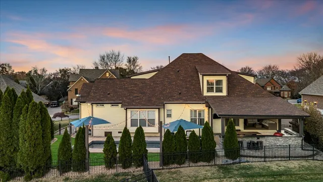 a view of a livingroom with furniture wooden floor a chandelier and windows