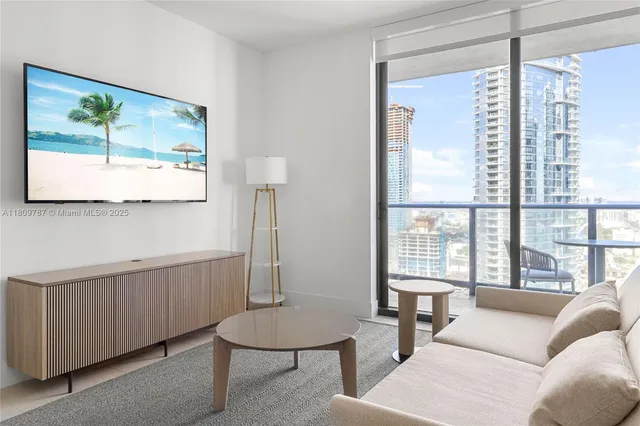 a living room with furniture a large window and a flat screen tv