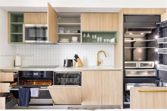 a kitchen with stainless steel appliances kitchen island granite countertop a refrigerator and a stove