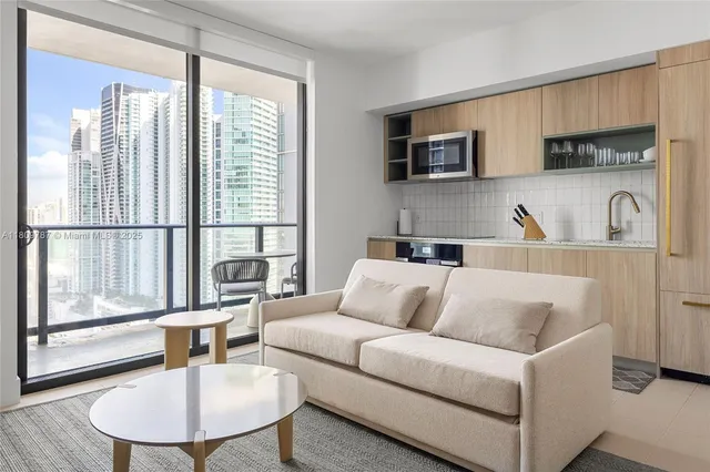 a living room with furniture a flat screen tv and windows