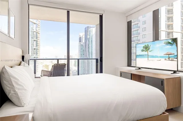 a large bed sitting in a bedroom next to a window