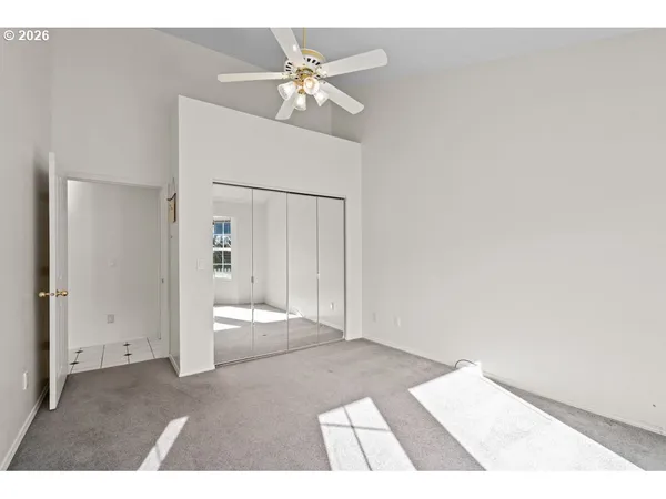 a view of an empty room with a chandelier fan