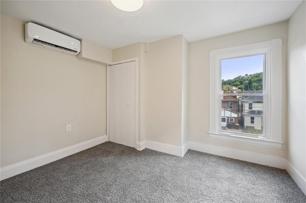 422 Grove Street McKees Rocks, PA 15136 - Photo 19 of 35 Bedroom #2 features new windows, new carpet, a closet, and a split HVAC wall unit.