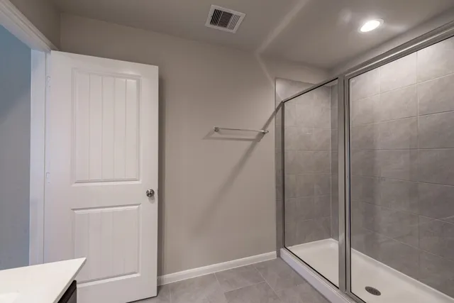 a bathroom with a shower and a glass door
