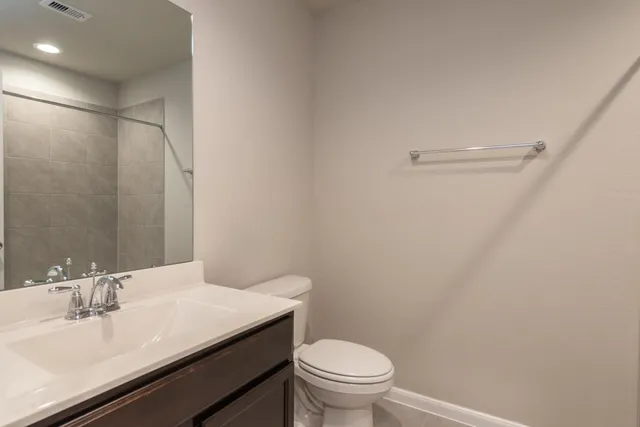 a bathroom with a sink a toilet and a mirror