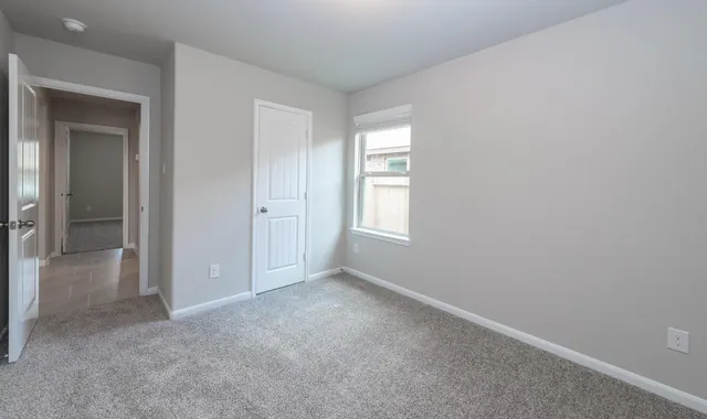 an empty room with windows and closet
