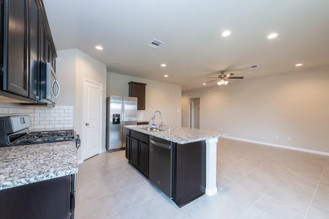 a kitchen with stainless steel appliances granite countertop a sink stove and refrigerator