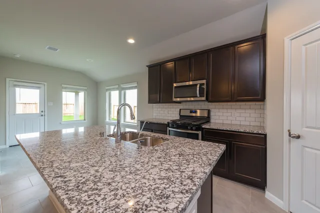 a kitchen with a stove sink and microwave