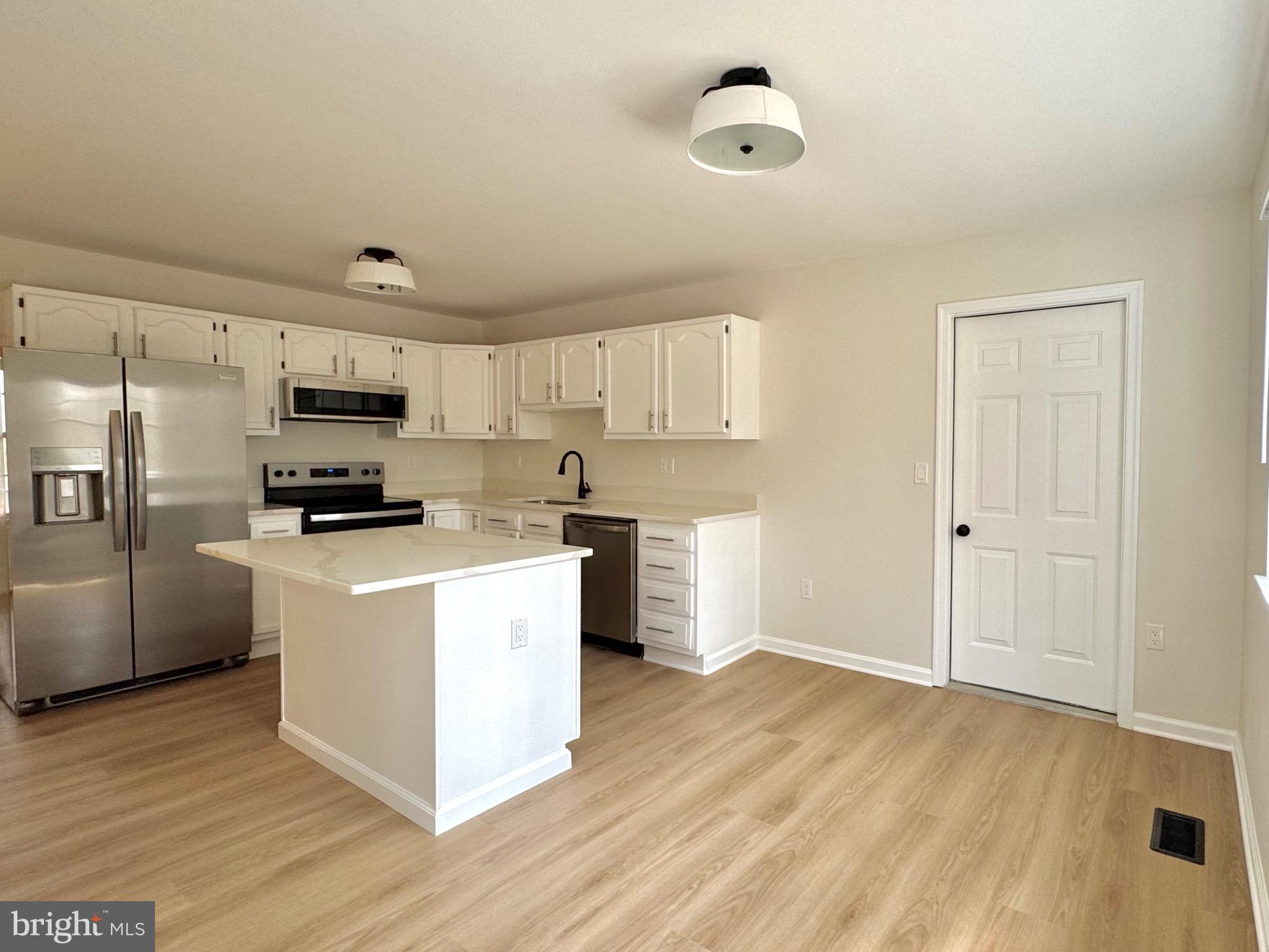 640 Santa Fe Trail Lusby, MD 20657 - Photo 7 of 26 a kitchen with stainless steel appliances granite countertop a refrigerator a stove top oven a sink and dishwasher with wooden floor