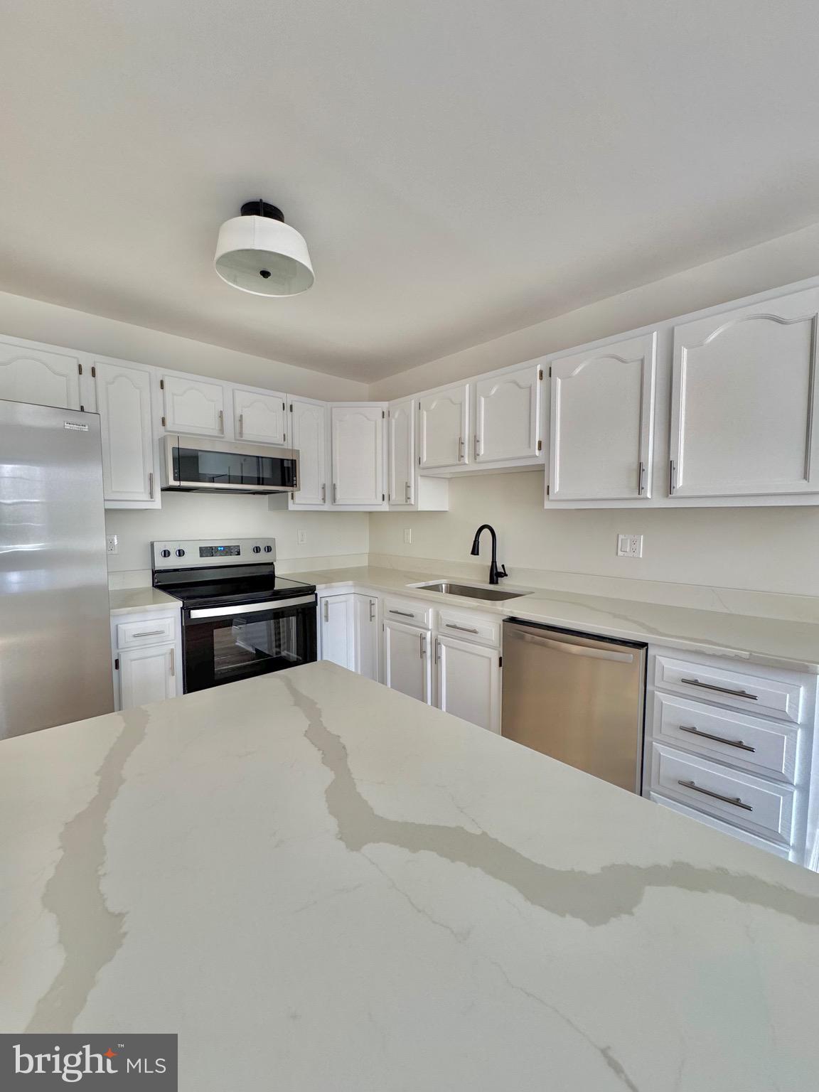 640 Santa Fe Trail Lusby, MD 20657 - Photo 10 of 26 a kitchen with granite countertop a stove top oven and cabinets