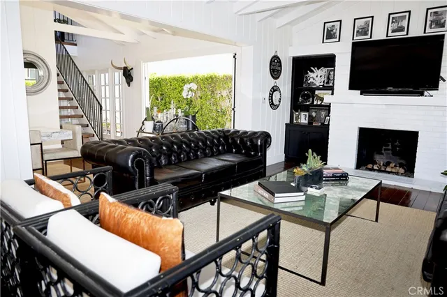 a living room with furniture a flat screen tv and a fireplace